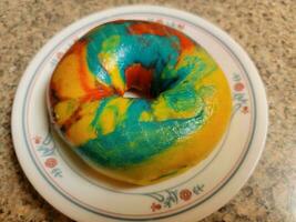 colorful bright rainbow bagel with many colors on plate photo