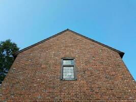 red brick or masonry building with window and sky photo