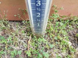 rain gauge in the ground or lawn or yard with measurement markings photo