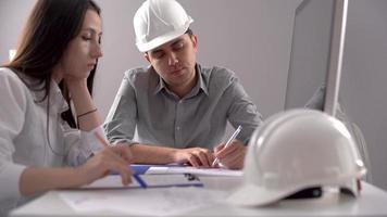 dos ingenieros trabajando en el proyecto. dos ingenieros trabajando en un proyecto en el trabajo. uno es hembra y el otro es macho. video