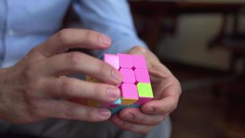 Rubiks kubus. de man die met de hersenkraker speelt. kleurrijke hersenkraker. video