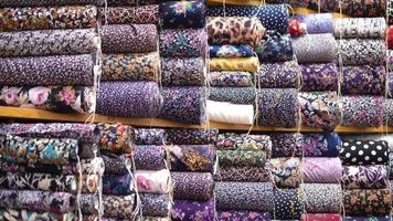 tipos de tecido, indústria têxtil. os tipos de tecidos alinhados nas prateleiras são utilizados na indústria têxtil. video