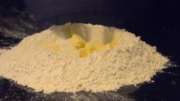 elaboración de masa Fase de preparación. la escena de verter mantequilla sólida en la harina. video