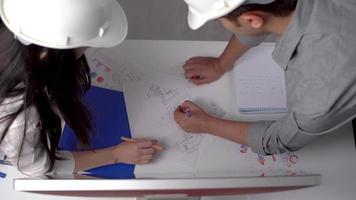 Engineers working and shaking hands. Engineers working on a project at a desk compromise and shake hands. video