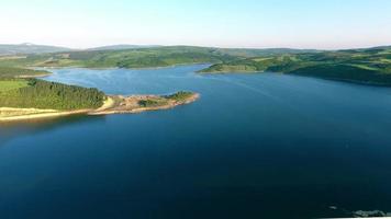 vista lago circondato da boschi lussureggianti. splendida vista lago con vista aerea. lago azzurro nella foresta lussureggiante. video