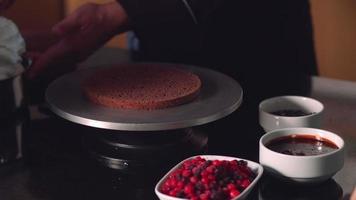 Video of applying cream on cake cake. Pastry master.