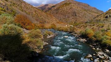 ruscello e ponte storico in autunno. ottima vista sulle acque del torrente e sul ponte storico. video