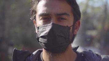 Porträt eines Teenagers in schwarzer Maske. Brunettestudent, der Kamera betrachtet. Nahansicht. video