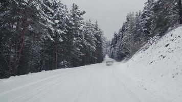 Car driving on snowy road in forest. Car driving on snowy and icy road in forest. video