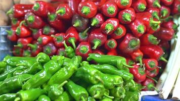 rote und grüne Paprika. rote und grüne Chilischoten auf der Theke erhältlich. video