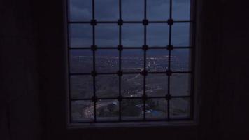 Watching the city at night through the bars. The city that seems far away. video