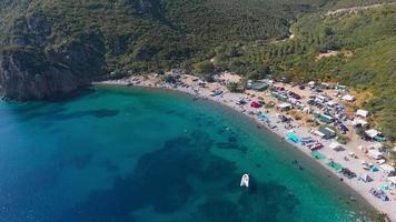 Leute, die am Strand schwimmen. Luftvideo. Küste. Der Strand ist von üppigen Wäldern umgeben. video