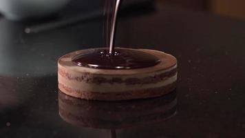 chocolate quente derramando sobre o bolo. confecção de bolos. mestre pasteleiro. video