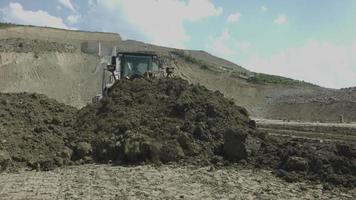 costruzione di dighe. macchine da lavoro. spendendo denaro. camion movimento terra. autocarri con cassone ribaltabile per sabbia. sito di costruzione. lavoro a terra. palline di sabbia. operaio edile. video