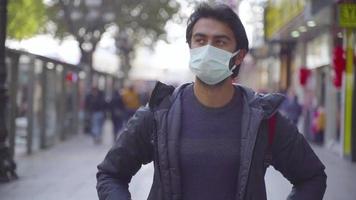 student portret. man lopen naar camera. dagelijks leven leven. levensstijl. lopen op de drukke straat. pandemische omstandigheden. video