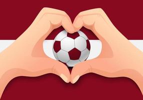 Balón de fútbol de Letonia y forma de corazón de mano vector