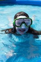 smiling young girl in swim goggles at pool photo