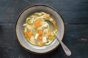 homemade chicken soup with vegetables flat lay photo