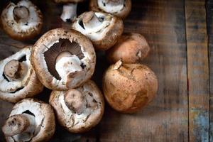 Fresh button mushrooms on antique tray and old wood table photo