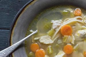 homemade chicken soup with vegetables flat lay photo