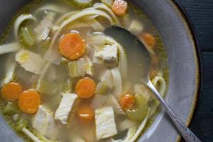homemade chicken soup with vegetables flat lay photo