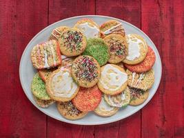oval platter of a variety of simple sugar cookies with sprinkles and icing flat lay photo