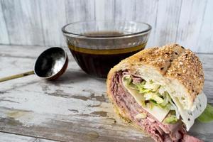 sándwich de rosbif con salsa de cebolla francesa caldo de res foto