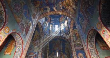Ceiling of an orthodox church. Beautiful light coming through the windows in the church dome. Holy figures. Shiny light. Detailed paintings. Colorful interior. Vibrant colors.