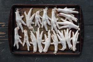 raw chicken feet on metal baking sheet flat lay photo