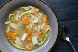 homemade chicken soup with vegetables flat lay photo