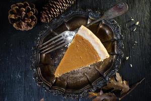 Pumpkin pie slice in fall holiday setting photo