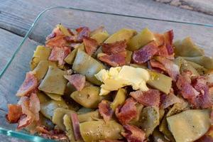 Dish of Italian green beans with bacon bits and butter flat lay photo