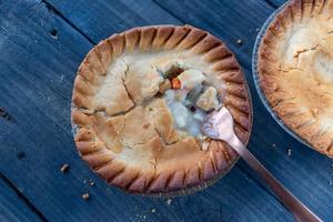 baked golden brown mini chicken pot pies on rustic background flat lay photo