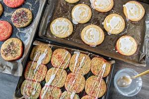 rociar azúcar blanco sobre galletas de azúcar horneadas con chispas rojas y verdes planas foto