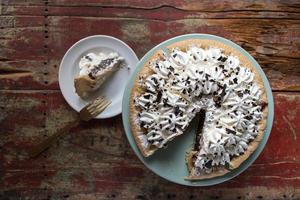 chocolate pie with meringue and slice cut out photo