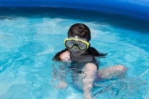 smiling young girl in swim goggles at pool photo