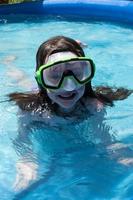 smiling young girl in swim goggles at pool photo