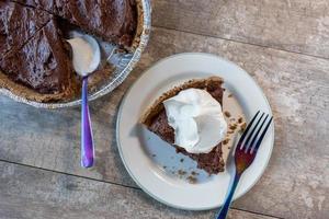 top view of chocolate pudding pie slice with whipped cream topping photo