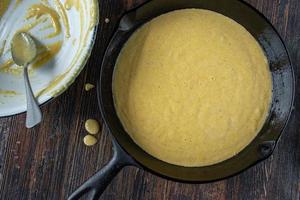 homemade cornbread batter in cast iron pan flat lay photo