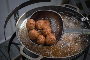 fried hushpuppies coming out of hot oil at fish fry photo