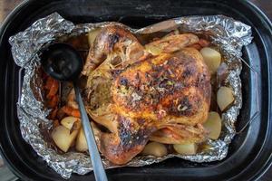 Thanksgiving baked turkey in roasting pan with potatoes and carrots photo