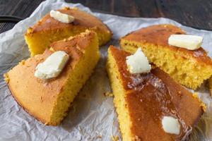 group of sliced homemade cornbread topped with melted butter photo