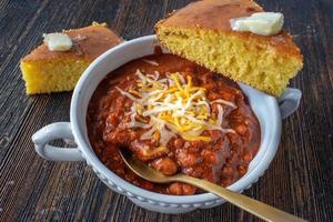 bowl of homemade chili with cornbread top view photo