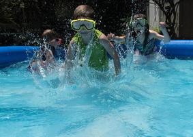 young kids running in water with goggles on in pool photo