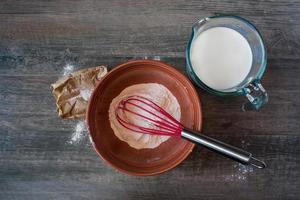 Mixing vanilla pudding with ingredients on rustic table Flat lay photo