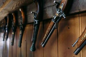 A set of old pistols on the shelf of a gift shop. Medieval weapons.