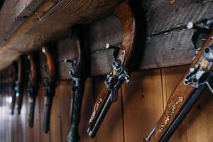 A set of old pistols on the shelf of a gift shop. Medieval weapons. photo