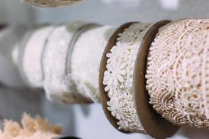 madejas de encaje cuelgan en un estante en una tienda de artesanía y artesanía. foto