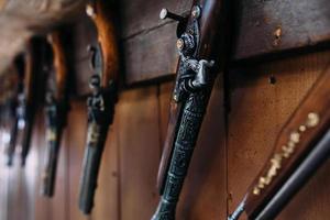 A set of old pistols on the shelf of a gift shop. Medieval weapons. photo