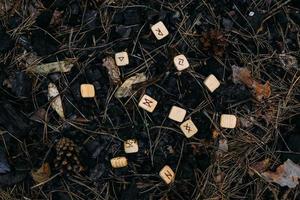 Runes scattered in old ashes. Occult, esoteric concept. photo